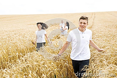 Happy family - brothers, sister and mom have fun on the wheat field. Summer vacation time Stock Photo