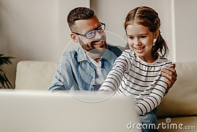 Happy family a businessman father working at a computer and his child daughter at home Stock Photo