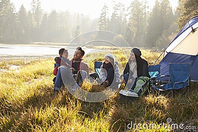 Happy family on a camping trip relaxing by their tent Stock Photo