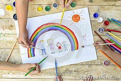 Happy family concept. Co-creation. Children hands draw on a sheet of paper: father, mother, boy and girl hold hands against Stock Photo