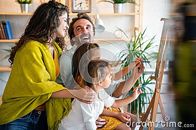 Happy family concept. Young parents with children painting together at home. People fun happyiness. Stock Photo