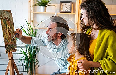 Happy family concept. Young parents with children painting together at home. People fun happyiness. Stock Photo