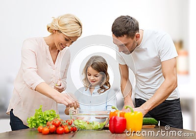 Happy family cooking vegetable salad for dinner Stock Photo