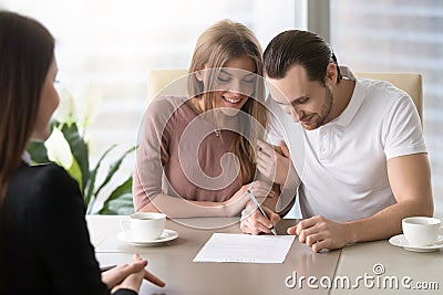 Happy family couple signing document, taking out bank loan, insu Stock Photo