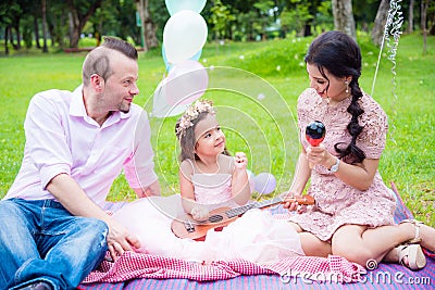 Happy family with a daughter playing music and sing a song Stock Photo