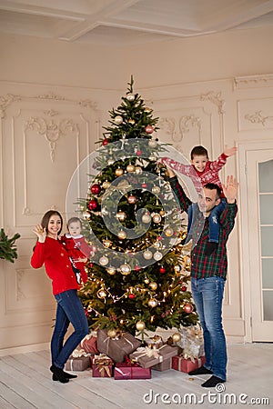 Happy family decorate the Christmas tree indoors together. Loving family. Merry Christmas and Happy Holidays Stock Photo