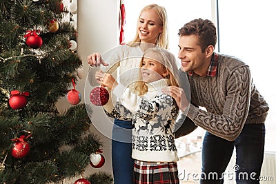 Happy family decorating christmas tree at home Stock Photo