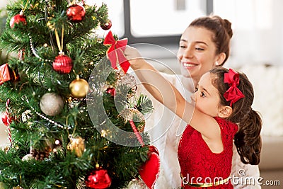 Happy family decorating christmas tree at home Stock Photo