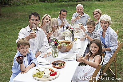 Happy Family Dining Together In Garden Stock Photo