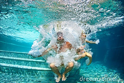 Happy family diving underwater with fun in swimming pool Stock Photo