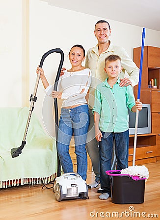 Happy family dusting in home Stock Photo
