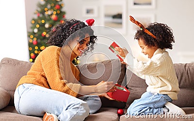 Ethnic mother and son opening Christmas presents together Stock Photo