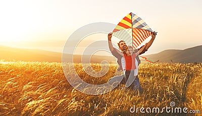 Happy family father and baby daughter launch kite on meadow Stock Photo