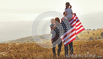 Happy family with flag of america USA at sunset outdoors Stock Photo