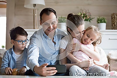 Smiling father making selfie of happy family of four Stock Photo