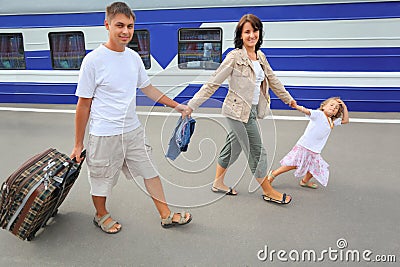 Happy family with girl going on railway station Stock Photo