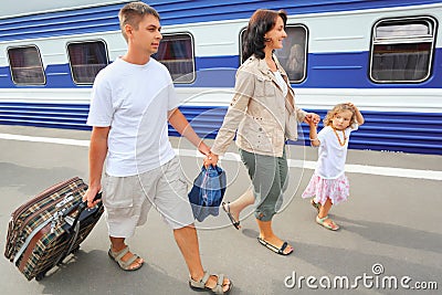 Happy family with girl going on railway station Stock Photo