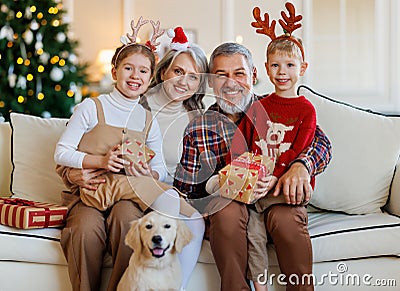 Happy family grandparents, grandchildren and dog golden retriever during Christmas holidays at home Stock Photo