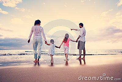 Happy Family have Fun Walking on Beach at Sunset Stock Photo