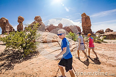 Happy family hiking together in the beautiful rock formations of Arches National Park Stock Photo