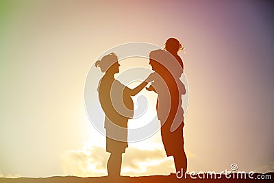 Happy family including pregnant mother, father toddler at sunset Stock Photo