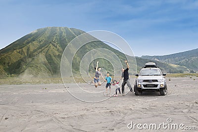 Happy family jump on volcanic desert Stock Photo