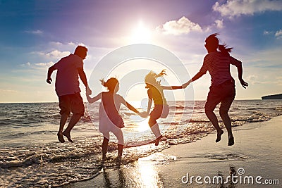 Happy family jumping on the beach Stock Photo