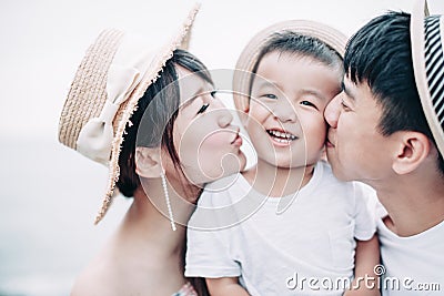 Happy family kissing the child on the Stock Photo
