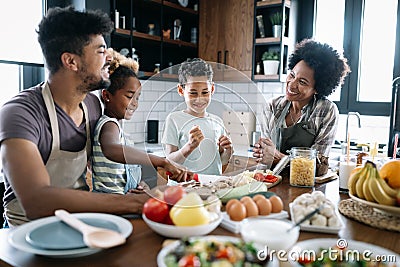 Happy family in the kitchen having fun and cooking together. Healthy food at home. Stock Photo