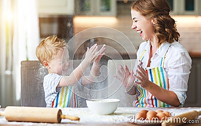 Happy family in kitchen. mother and child preparing dough, bake cookies Stock Photo