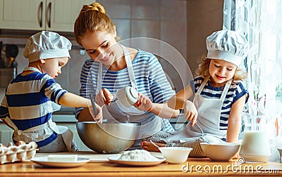 Happy family in kitchen. mother and children preparing dough, ba Stock Photo