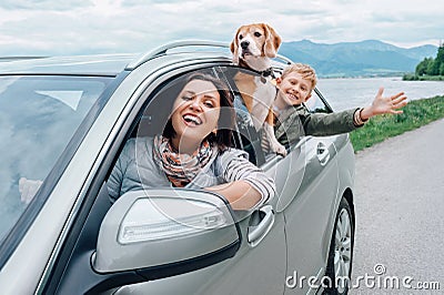 Happy family look out from car windows Stock Photo