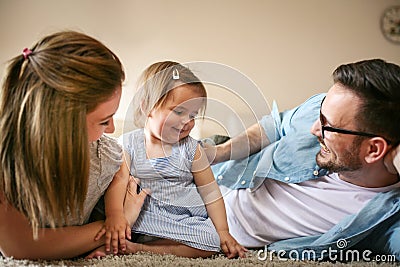 Happy family lying on floor with their little baby. Stock Photo