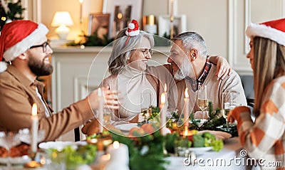 Happy family sharing gifts on Christmas morning, young and elderly couple exchanging xmas presents Stock Photo
