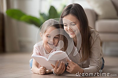 Happy family mom baby sitter and kid daughter reading book Stock Photo
