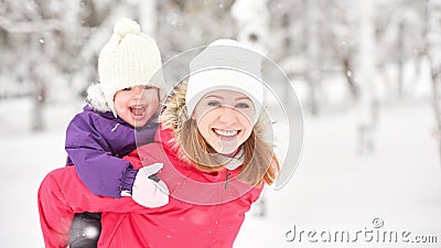 Happy family mother and baby girl daughter playing and laughing in winter snow Stock Photo