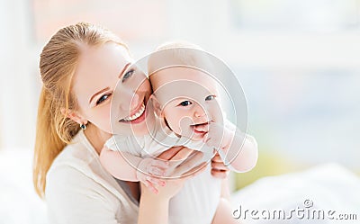 Happy family mother with baby playing and hug in bed Stock Photo