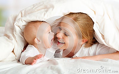 Happy family. Mother and baby playing under blanket Stock Photo