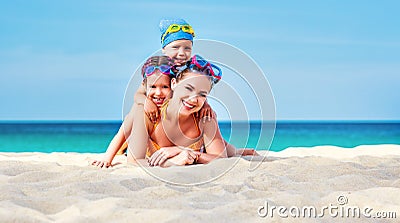 Happy family mother and chidren in masks on beach in summer Stock Photo