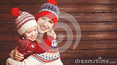 happy family mother and child girl with christmas hat hugs at wooden Stock Photo