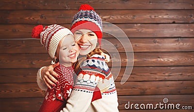 happy family mother and child girl with christmas hat hugs at wooden Stock Photo