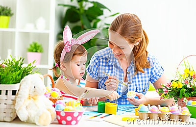 Happy family mother and child girl paints eggs for Easter Stock Photo