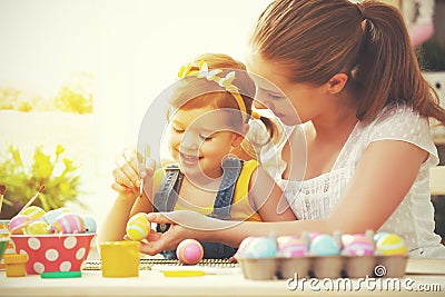 Happy family mother and child girl paints eggs for Easter Stock Photo