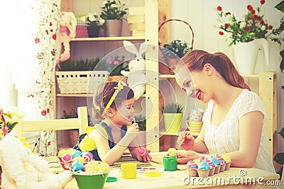 Happy family mother and child girl paints eggs for Easter Stock Photo