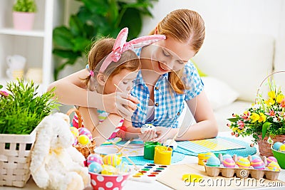 Happy family mother and child girl paints eggs for Easter Stock Photo