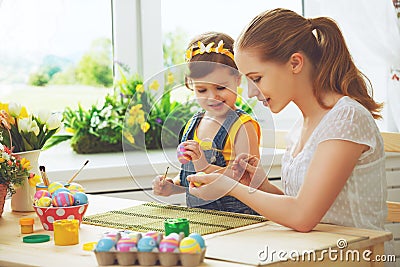 Happy family mother and child girl paints eggs for Easter Stock Photo