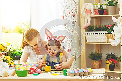 Happy family mother and child girl paints eggs for Easter Stock Photo