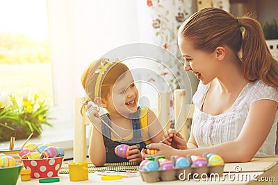 Happy family mother and child girl paints eggs for Easter Stock Photo