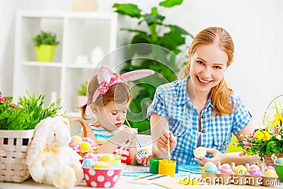 Happy family mother and child girl paints eggs for Easter Stock Photo