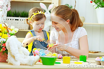 Happy family mother and child girl paints eggs for Easter Stock Photo